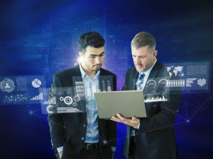An executive briefing room where cybersecurity analysts and business leaders review threat dashboards showing AI-driven attack patterns, phishing simulations, and risk metrics on large screens.